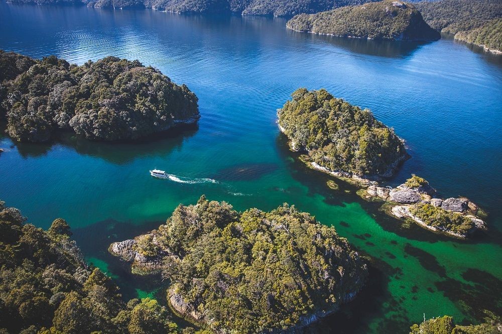 aerial view of boat in blue waters of Dusky Sound New Zealand