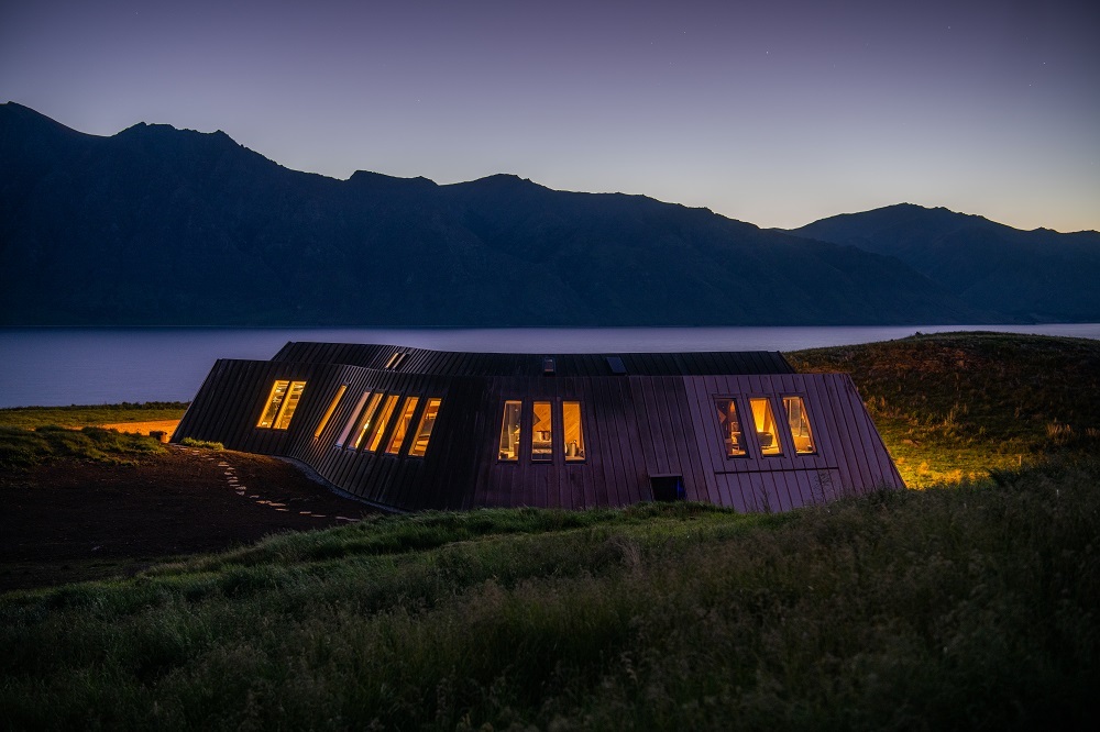 hotel cottage lit from inside in the dusk of New Zealand 