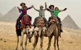 Travelers on a camel ride near the Pyramids of Giza.