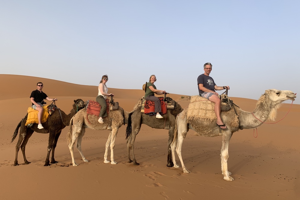 Sara Benda and her family riding camels in the Sahara, Morocco.