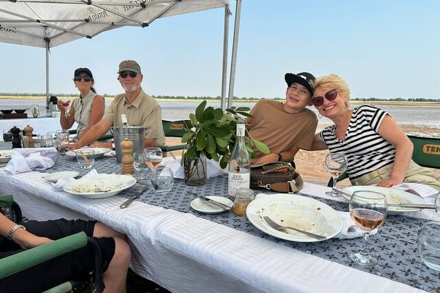 Tracy Goble and her family enjoying lunch on a sandbar of the Zambezi River, Zambia.