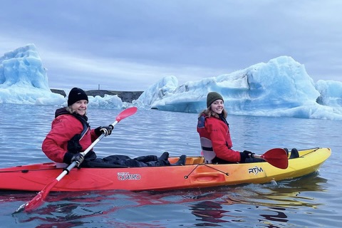 Travelers kayaking among icebergs in a glacial lagoon in Iceland.