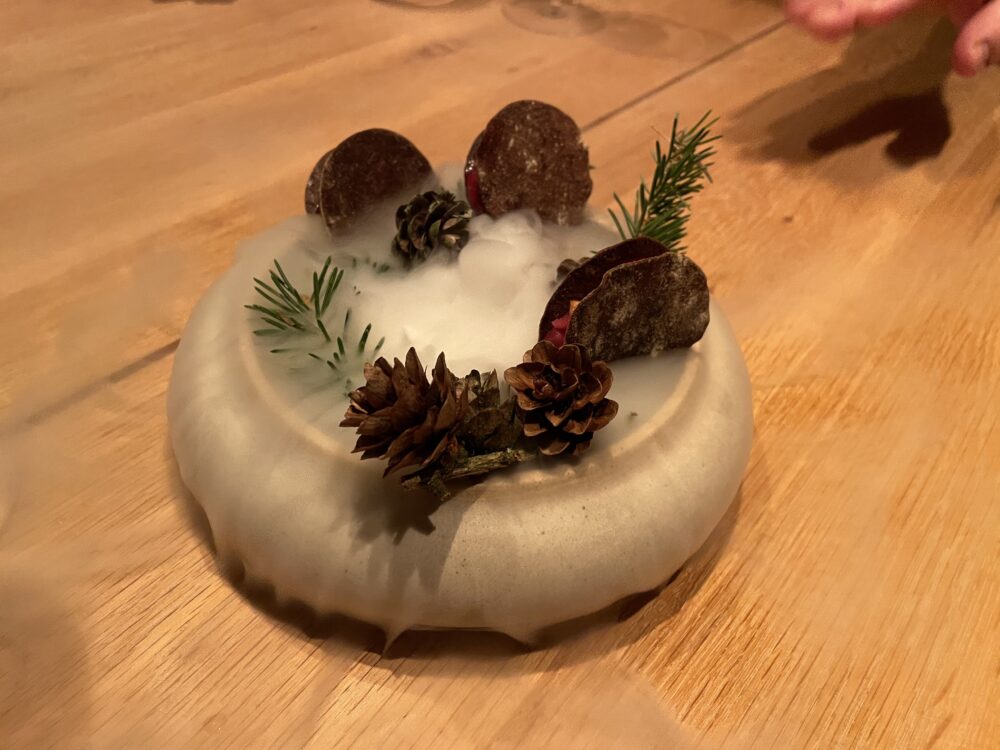 Bowl of mushrooms and moose and reindeer liver between rounds of porcini flatbread on a bed of smoking dry ice. Photo: Ryan Damm