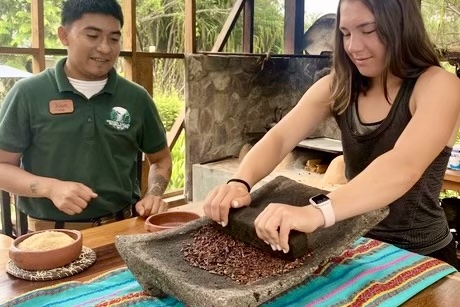 Kate Nury learning the fine art of chocolate making from Jose at Hidden Valley Inn, Belize.