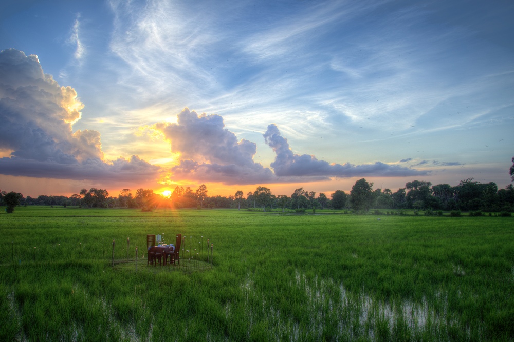 A table set on the field of Villa Chandara during sunset in Siem Reap, Cambodia.