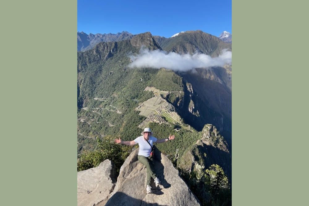 Kathleen Fitch sitting on top of Huayna Pichhu mountain in Peru.