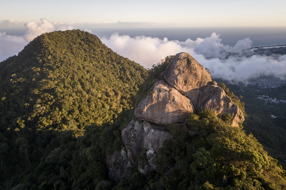 Sunset view on the rocky peak surrounded by rainforest, Tijuca Forest, Rio de Janeiro, Brazil.