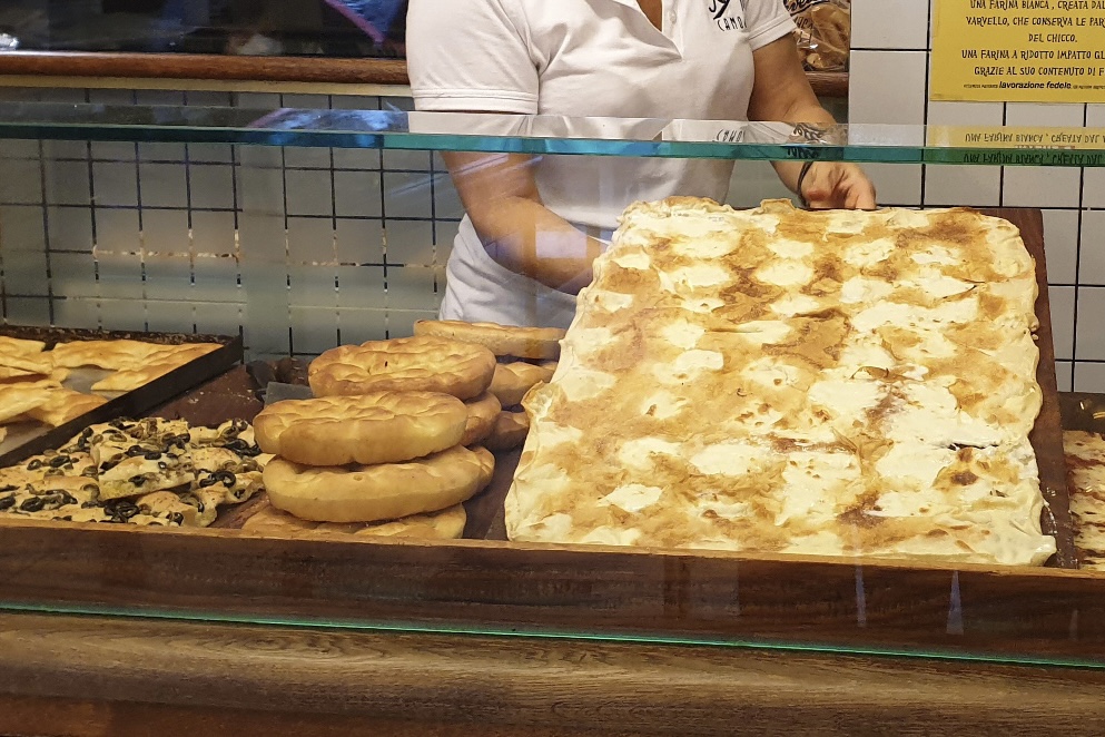 Person bringing in the cheese focaccia in a shop in Cinque Terre, Italy.