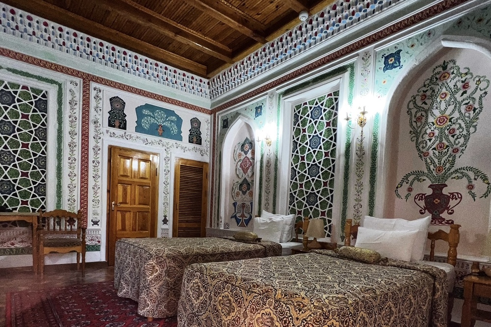 A hotel room with mural paintings at the Sasha and Son Boutique Hotel in Bukhara, Uzbekistan.