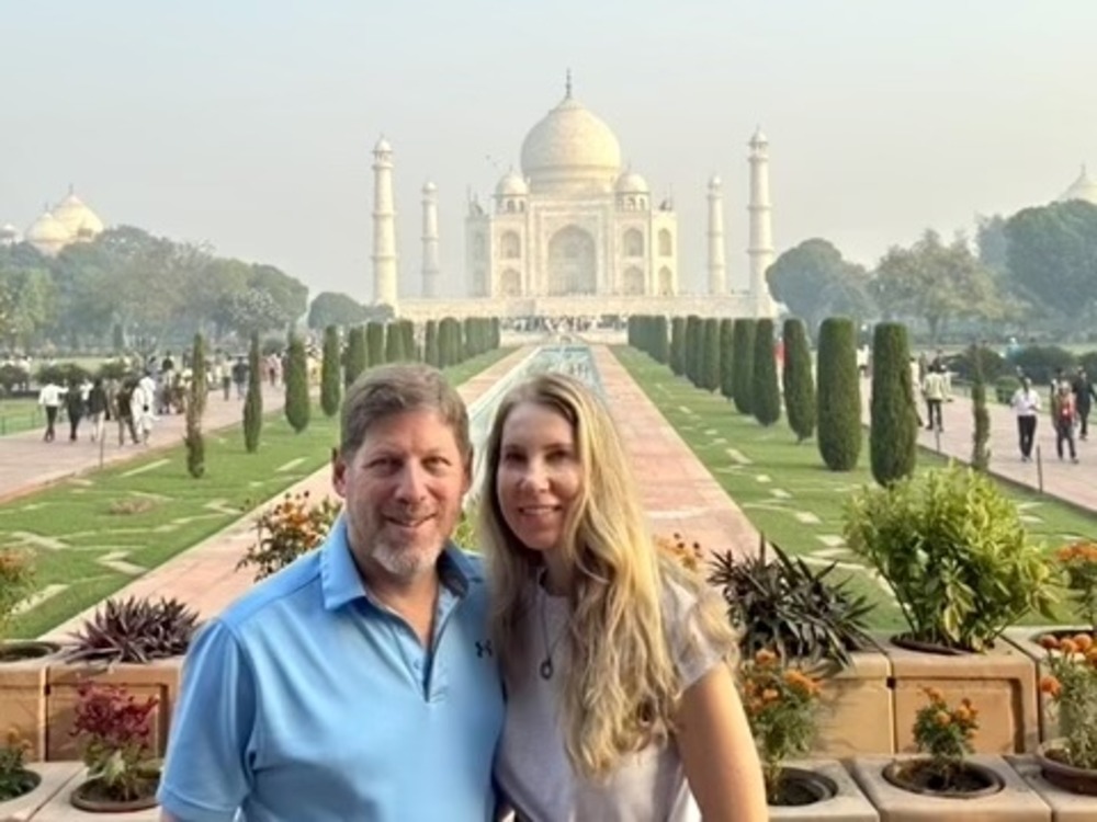 Giselle and Alan Weissman standing in front of Taj Mahal in India.