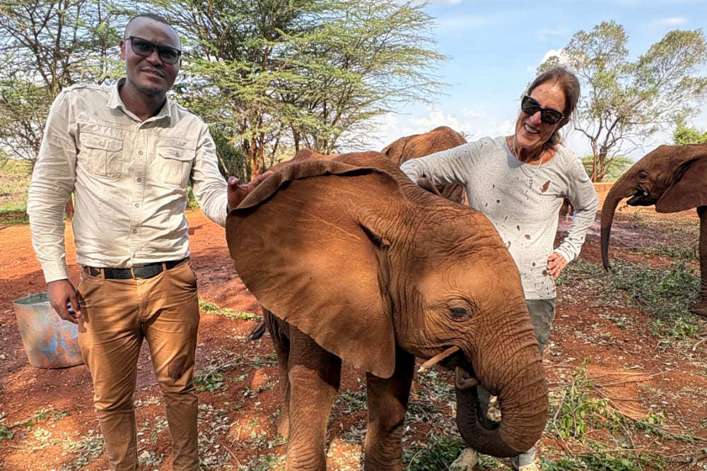 Dawn Critchley with her guide Duncan and a baby elephant at Sheldrick Wildlife Trust, Kenya.