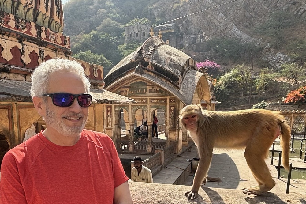 Richard Mitchell posing with a monkey near a temple, in Jaipur, India.