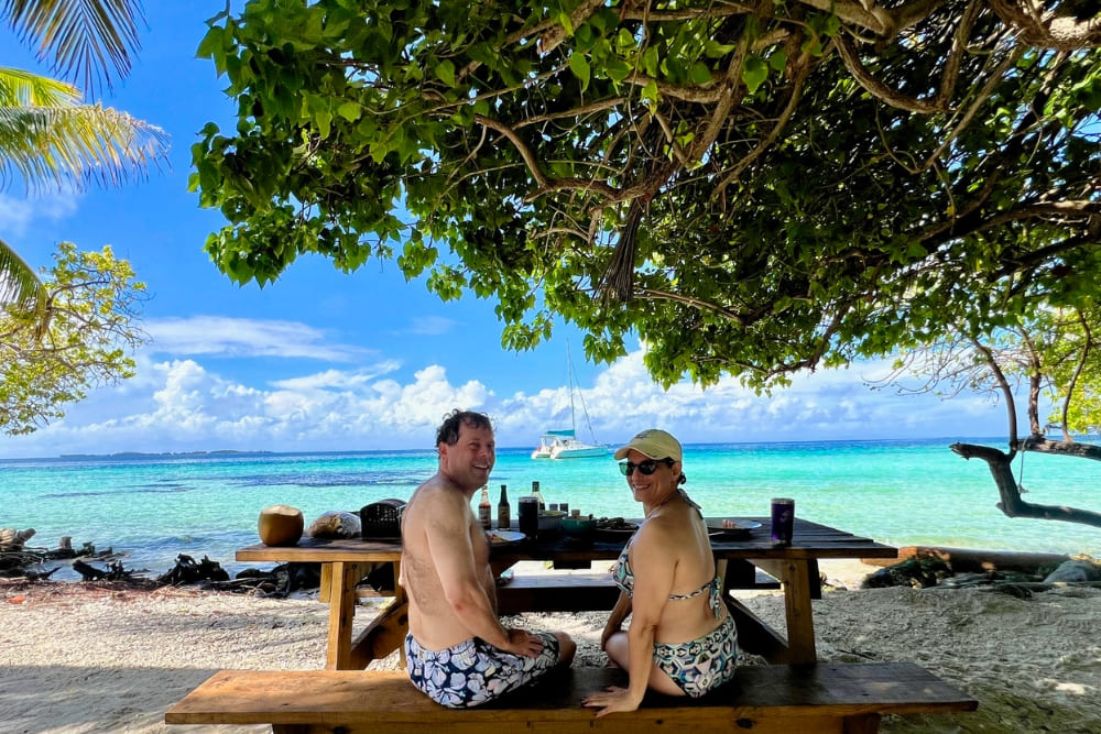 Laurie and Michael Schuftan having a picnic on a beach in Moho Caye, Belize.