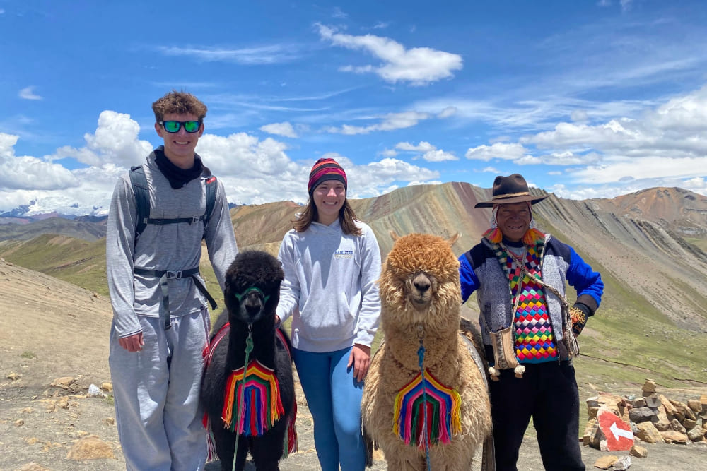 Will and Kate Nury with a local and his alpaca in Palcoyo, Peru.