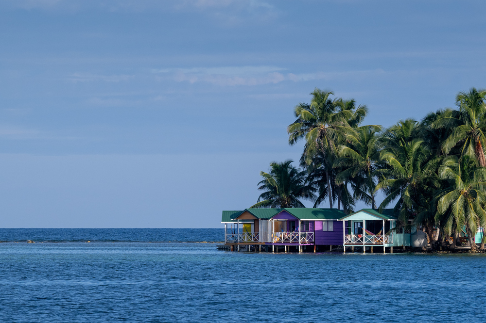 Palm trees and wooden houses of an island in Belize.