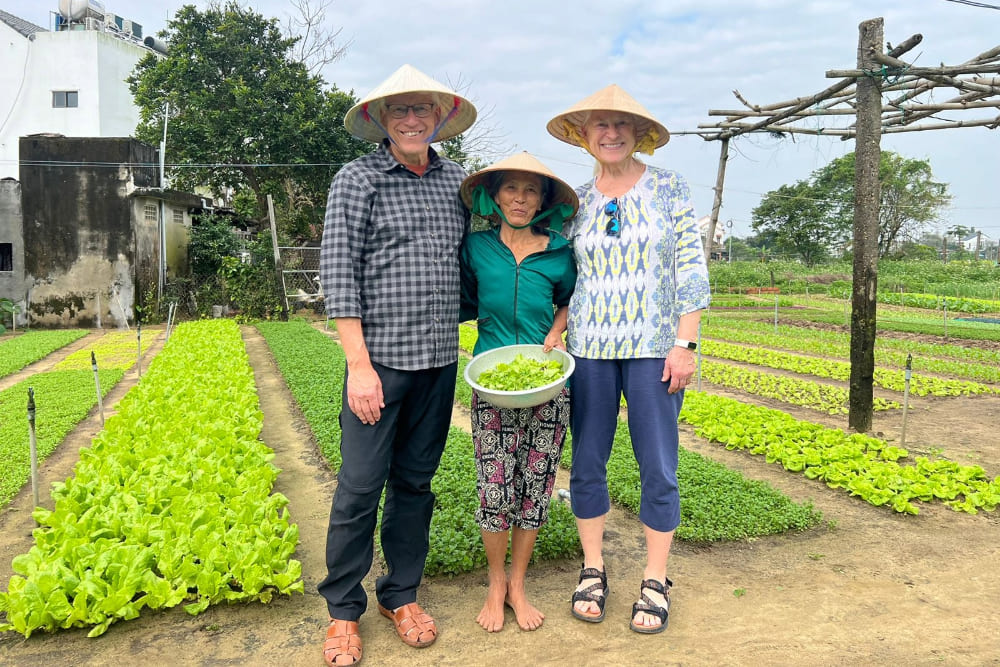 Chris and Lisa Wollan alongside an organic farmer near Hoi An in Vietnam.