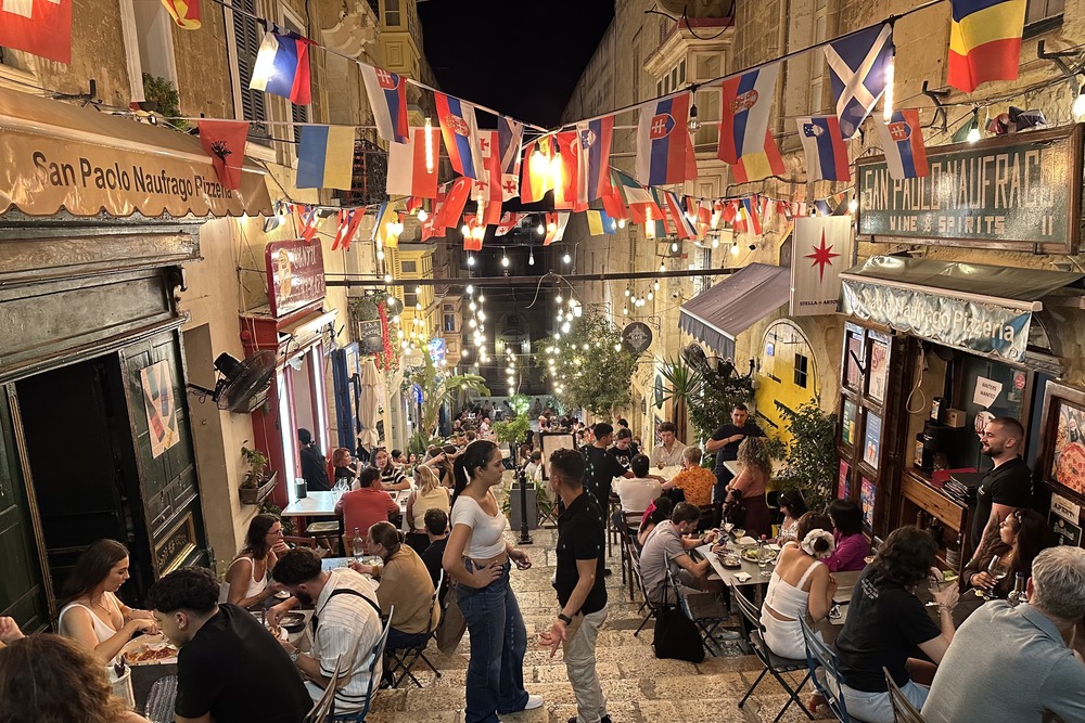 View of a busy street and restaurants in Valletta, Malta.