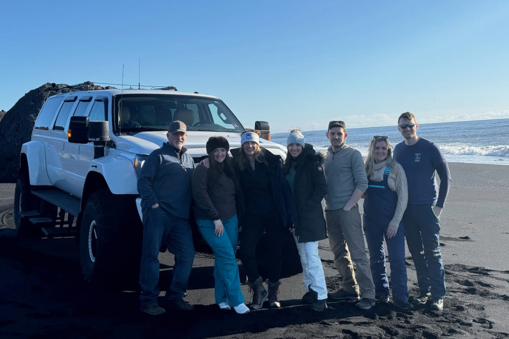 Gail Fennell and family next to a monster on a black beach in Iceland.