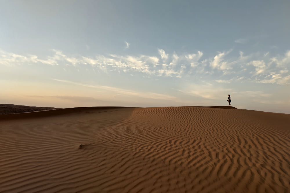 Jenifer Bunis in the Wahiba Sands desert at sunset.